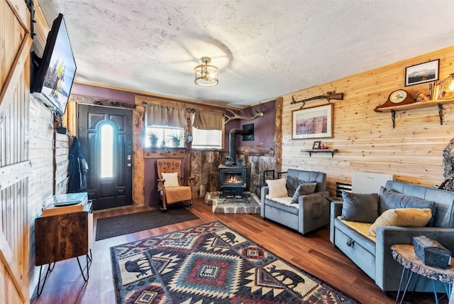 50 Puma Ct, Como, CO 80432 - living room featuring wood finished floors, wood walls, a textured ceiling, and a wood stove