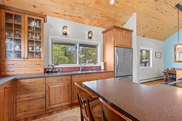 1750 Fish Creek Falls Rd, Steamboat Springs, CO 80487 - kitchen featuring a sink, stainless steel refrigerator, baseboard heating, dark countertops, and light wood-style floors