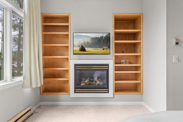1750 Fish Creek Falls Rd, Steamboat Springs, CO 80487 - unfurnished living room with baseboard heating, carpet floors, baseboards, a glass covered fireplace, and built in shelves