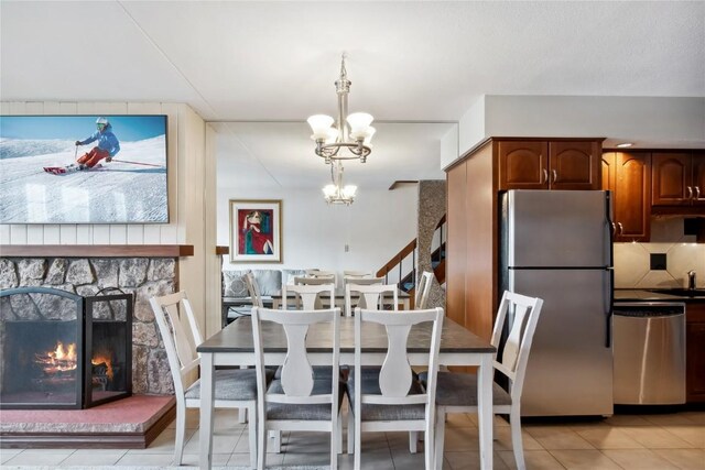 631 Village Rd Unit 36450, Breckenridge, CO 80424 - dining space with a notable chandelier, a stone fireplace, and light tile patterned floors