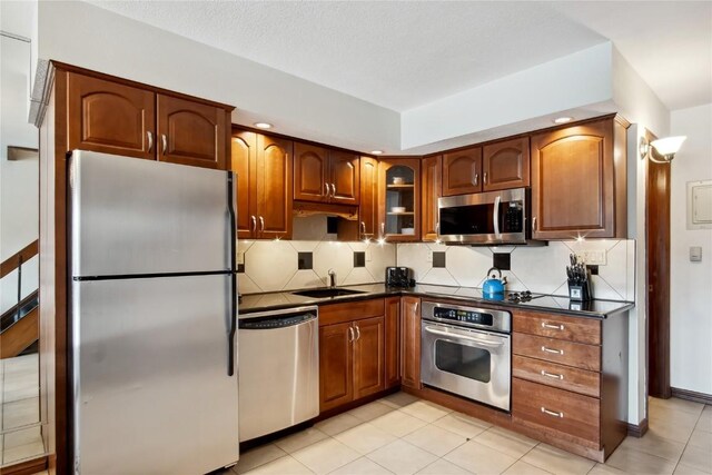631 Village Rd Unit 36450, Breckenridge, CO 80424 - kitchen featuring dark countertops, a sink, appliances with stainless steel finishes, and tasteful backsplash