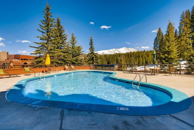 631 Village Rd Unit 36450, Breckenridge, CO 80424 - community pool with fence, a patio area, and a mountain view