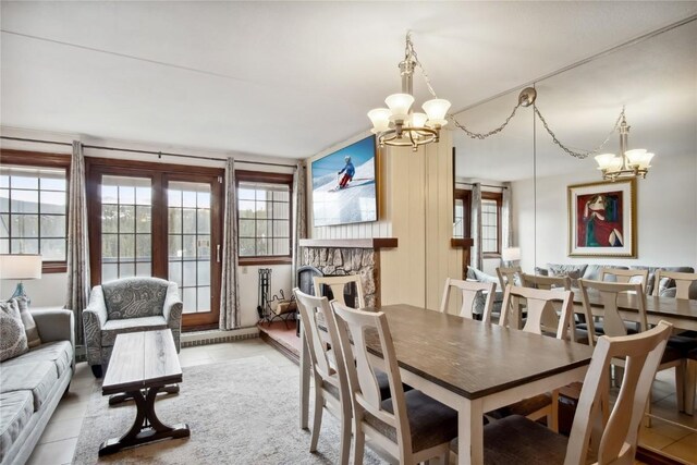 631 Village Rd Unit 36450, Breckenridge, CO 80424 - dining space with a stone fireplace, tile patterned floors, and a notable chandelier