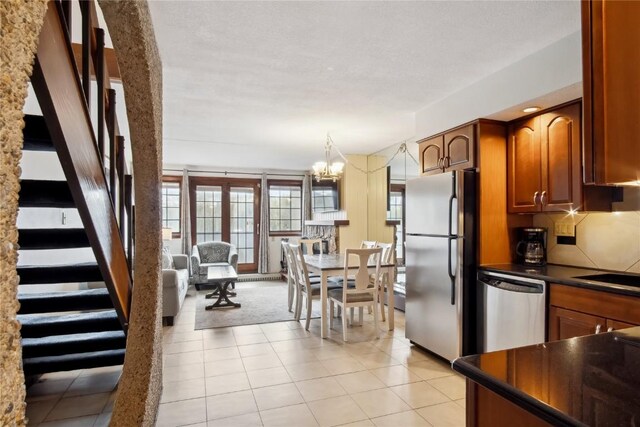631 Village Rd Unit 36450, Breckenridge, CO 80424 - kitchen featuring brown cabinets, an inviting chandelier, dark countertops, light tile patterned floors, and appliances with stainless steel finishes