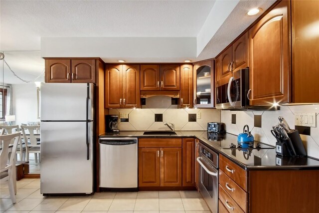 631 Village Rd Unit 36450, Breckenridge, CO 80424 - kitchen featuring dark countertops, a sink, brown cabinets, backsplash, and appliances with stainless steel finishes