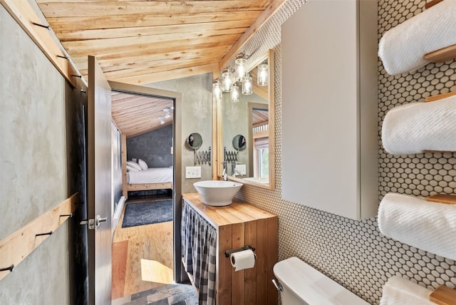 bathroom featuring wooden ceiling, lofted ceiling, toilet, and connected bathroom