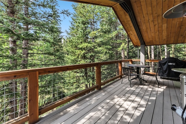 wooden deck featuring outdoor dining space and a grill