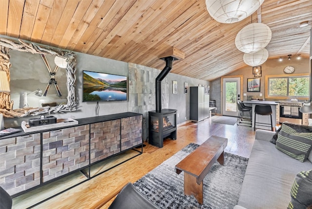 living area with wooden ceiling, a wood stove, wood finished floors, and lofted ceiling