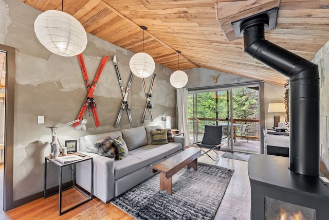 living room featuring vaulted ceiling, wood ceiling, a wood stove, and wood finished floors