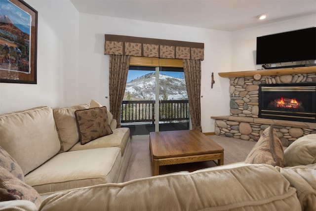 carpeted living room featuring recessed lighting, a stone fireplace, and baseboards