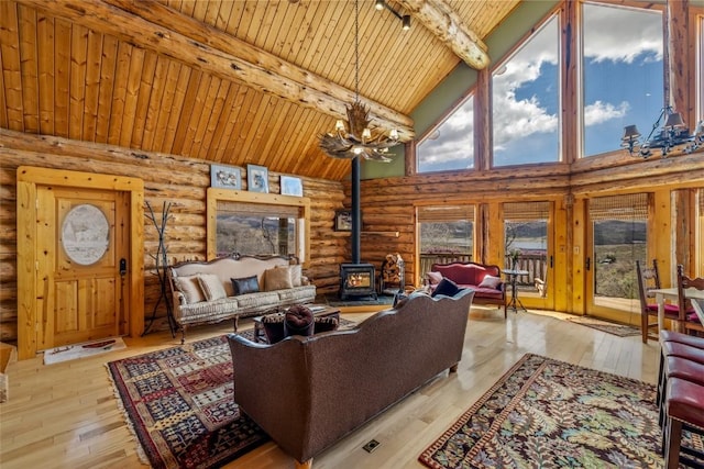 24110 Arapahoe Rd, Oak Creek, CO 80467 - living room featuring a wood stove, rustic walls, beamed ceiling, and high vaulted ceiling