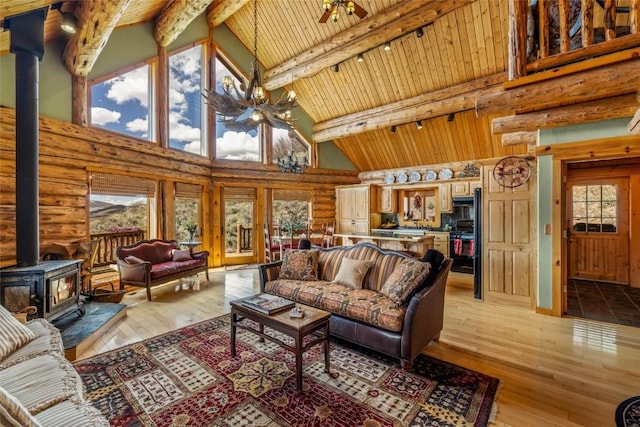 24110 Arapahoe Rd, Oak Creek, CO 80467 - living area with a wood stove, ceiling fan, high vaulted ceiling, and rustic walls