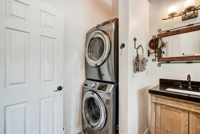 washroom with stacked washing maching and dryer, a sink, and laundry area