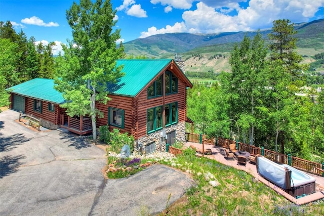 exterior space featuring stone siding, log siding, and a mountain view
