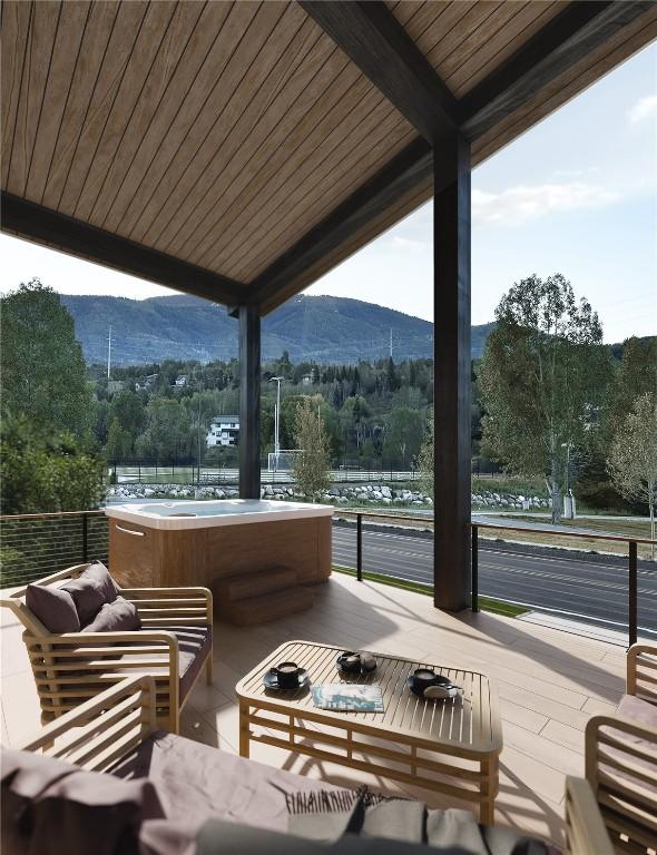 view of patio / terrace featuring a hot tub, a mountain view, and outdoor lounge area