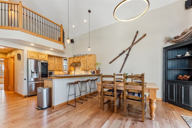 960 Whispering Pines Ln, Breckenridge, CO 80424 - kitchen featuring light wood-type flooring, a peninsula, a healthy amount of sunlight, and stainless steel fridge with ice dispenser