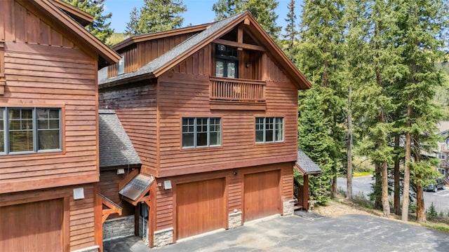 960 Whispering Pines Ln, Breckenridge, CO 80424 - view of front facade with board and batten siding, a garage, asphalt driveway, and roof with shingles