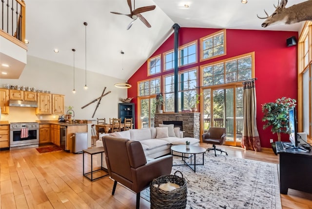 960 Whispering Pines Ln, Breckenridge, CO 80424 - living room with high vaulted ceiling, a stone fireplace, ceiling fan, light wood finished floors, and recessed lighting