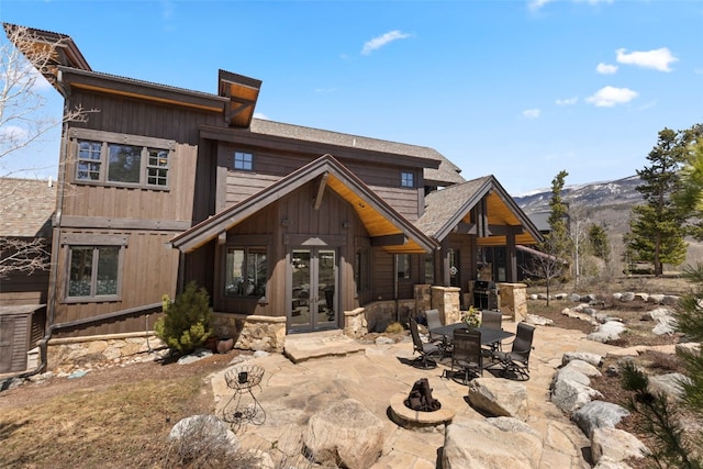 210 Game Trail Rd, Silverthorne, CO 80498 - back of house featuring a patio area, french doors, stone siding, a mountain view, and board and batten siding