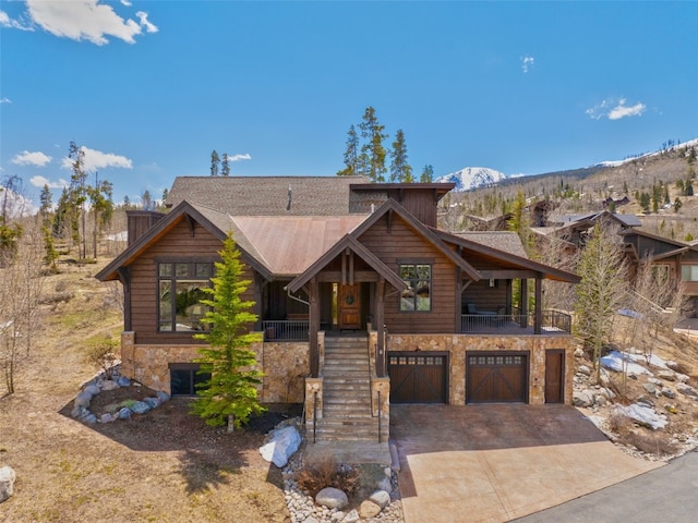 210 Game Trail Rd, Silverthorne, CO 80498 - view of front facade featuring stone siding, a mountain view, a garage, concrete driveway, and stairway
