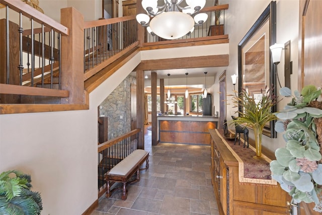 210 Game Trail Rd, Silverthorne, CO 80498 - hall featuring a notable chandelier, stone finish floor, baseboards, a towering ceiling, and stairway
