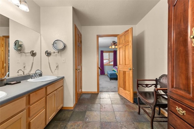 27426 Brandon Cir, Steamboat Springs, CO 80487 - full bathroom featuring baseboards, stone tile flooring, and double vanity