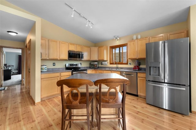 27426 Brandon Cir, Steamboat Springs, CO 80487 - kitchen with stainless steel appliances, light brown cabinets, vaulted ceiling, and light wood-style flooring