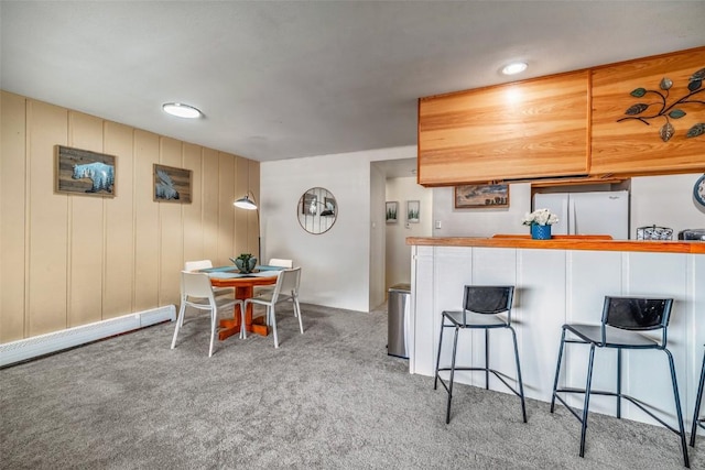 370 E Ln Bonte St Unit A, Dillon, CO 80435 - interior space featuring light colored carpet, a kitchen breakfast bar, and freestanding refrigerator