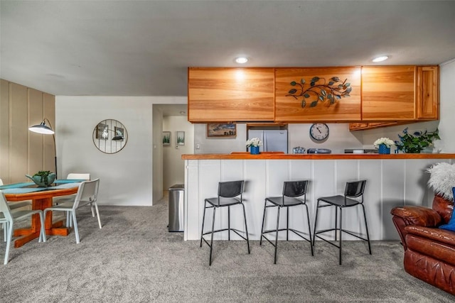 370 E Ln Bonte St Unit A, Dillon, CO 80435 - kitchen featuring carpet, recessed lighting, a kitchen breakfast bar, and freestanding refrigerator