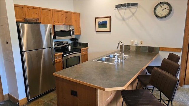 53 Hunki Dori Ct Unit 8905, Keystone, CO 80435 - kitchen with stainless steel appliances, a peninsula, dark countertops, and a breakfast bar area