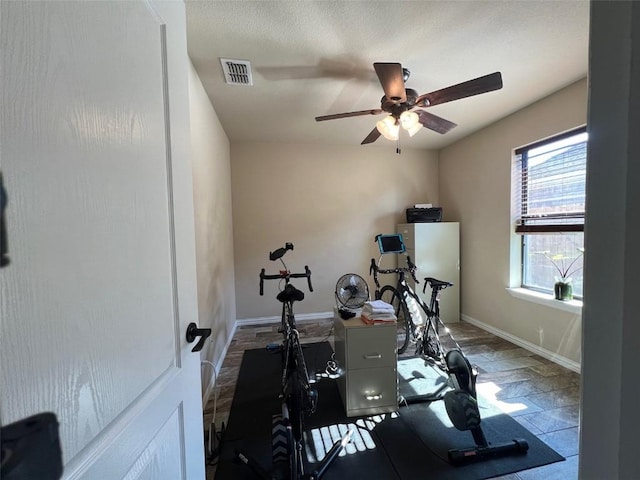 workout room featuring visible vents, baseboards, and ceiling fan