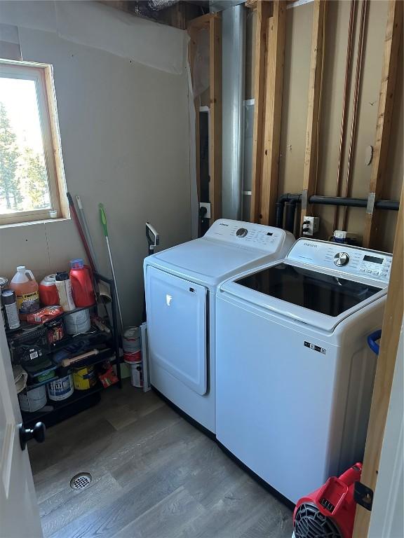 laundry room with wood finished floors, laundry area, and independent washer and dryer