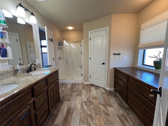 bathroom featuring a sink, double vanity, and a stall shower
