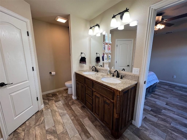 bathroom with double vanity, ensuite bath, toilet, and a sink
