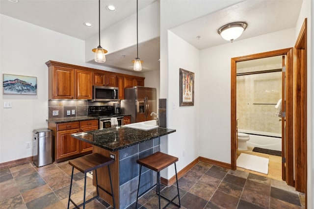 101 E Main St Unit 301, Frisco, CO 80443 - kitchen featuring appliances with stainless steel finishes, baseboards, a breakfast bar, dark stone finish flooring, and recessed lighting