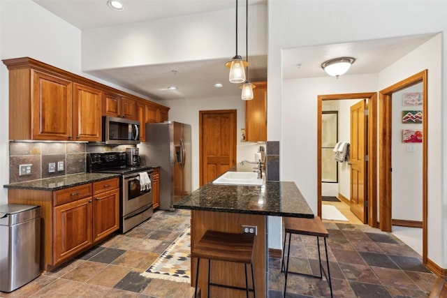 101 E Main St Unit 301, Frisco, CO 80443 - kitchen featuring appliances with stainless steel finishes, a sink, a kitchen breakfast bar, backsplash, and dark stone finish flooring