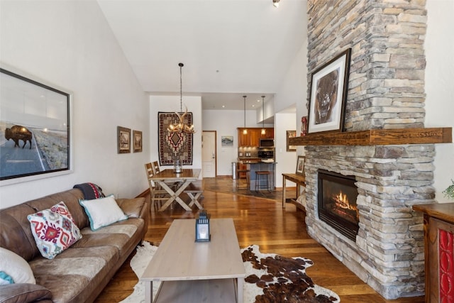 101 E Main St Unit 301, Frisco, CO 80443 - living room with high vaulted ceiling, a stone fireplace, dark wood-style flooring, and a chandelier