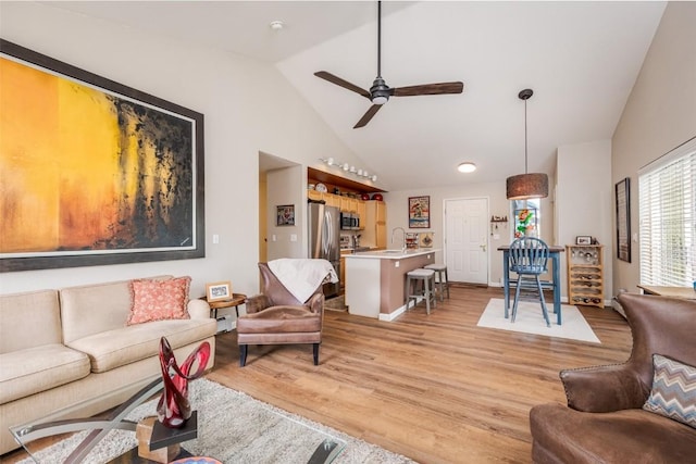 1399 Morgan Ct Unit 704, Steamboat Springs, CO 80487 - living room featuring lofted ceiling, a ceiling fan, and light wood-style flooring