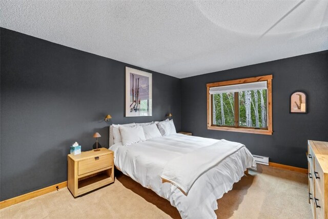 1655 Ranch Rd Unit 403, Steamboat Springs, CO 80487 - bedroom with a baseboard radiator, a textured ceiling, carpet flooring, and baseboards
