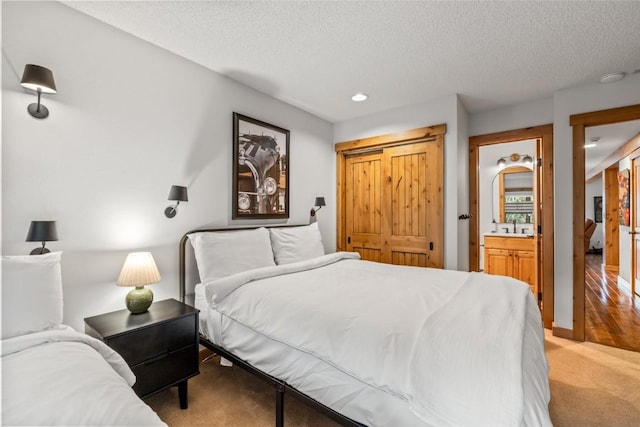1655 Ranch Rd Unit 403, Steamboat Springs, CO 80487 - bedroom with a textured ceiling, light colored carpet, recessed lighting, and a sink
