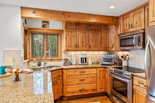 1655 Ranch Rd Unit 403, Steamboat Springs, CO 80487 - kitchen featuring appliances with stainless steel finishes, a sink, light stone countertops, decorative backsplash, and recessed lighting