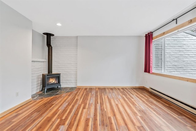 6 Sequoia Ct Unit 6, Steamboat Springs, CO 80487 - unfurnished living room with a baseboard heating unit, a wood stove, wood finished floors, baseboards, and recessed lighting