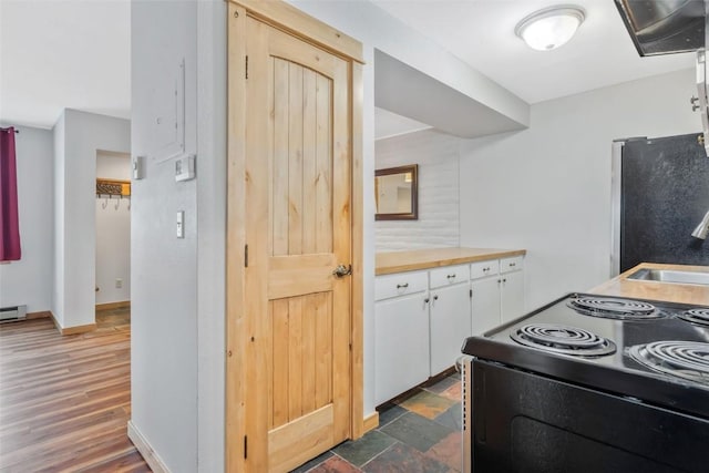 6 Sequoia Ct Unit 6, Steamboat Springs, CO 80487 - kitchen featuring black electric range oven, white cabinets, freestanding refrigerator, baseboards, and baseboard heating