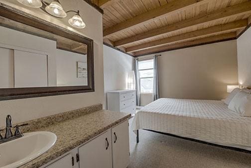 8500 Ryan Gulch Rd Unit 101, Silverthorne, CO 80498 - bedroom featuring a sink, wood ceiling, and beamed ceiling