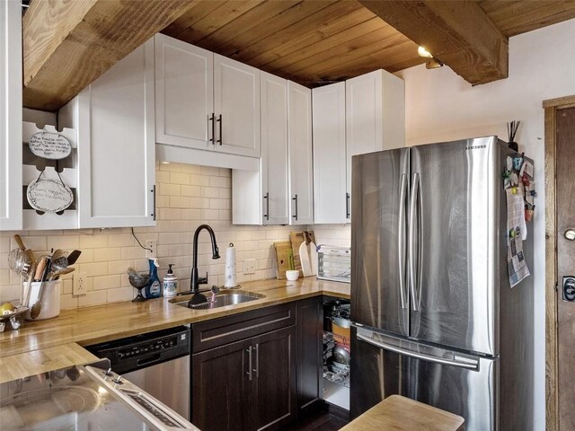 kitchen with tasteful backsplash, white cabinetry, stainless steel appliances, and a sink