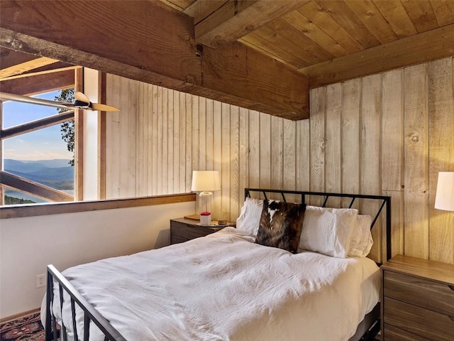 bedroom with wooden ceiling, wood walls, and beam ceiling