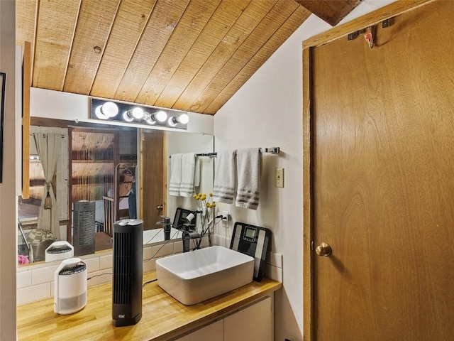 bathroom with vaulted ceiling, wood finished floors, wooden ceiling, and a sink