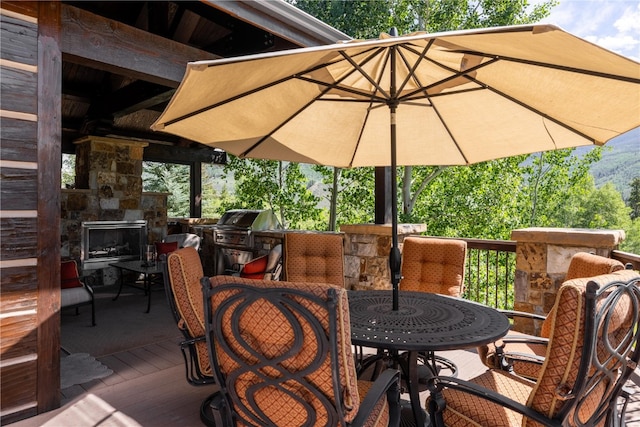 330 High Park Ct, Silverthorne, CO 80498 - deck with outdoor dining area, a grill, an outdoor stone fireplace, and exterior kitchen