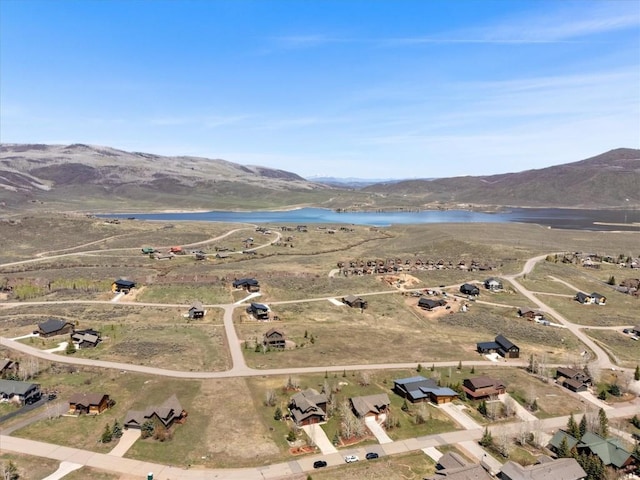 drone / aerial view featuring a water and mountain view