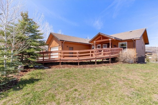back of property featuring a lawn, a wooden deck, and a garage